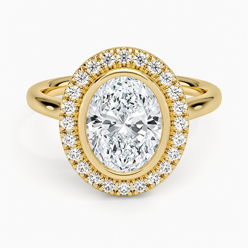 Oval moissanite bezel set inside a round pave halo on a yellow gold band, top view