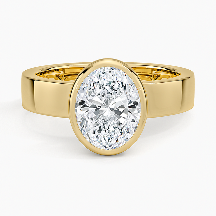 Full bezel oval moissanite on a wide flat yellow gold band, top view