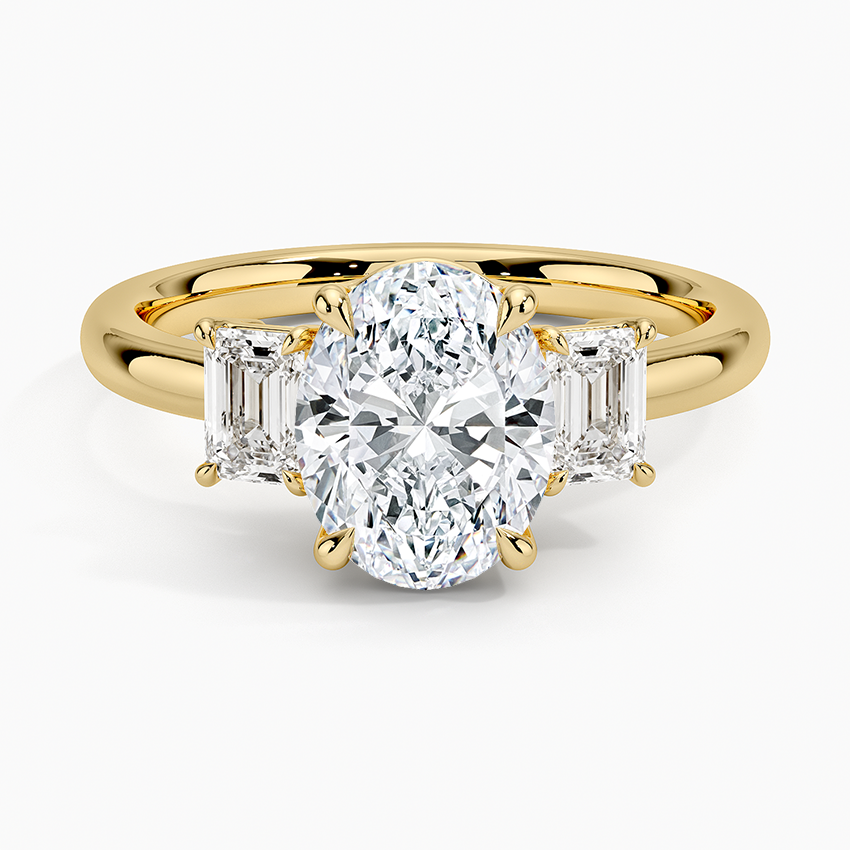 Oval moissanite with large emerald cut side stones in yellow gold, top view