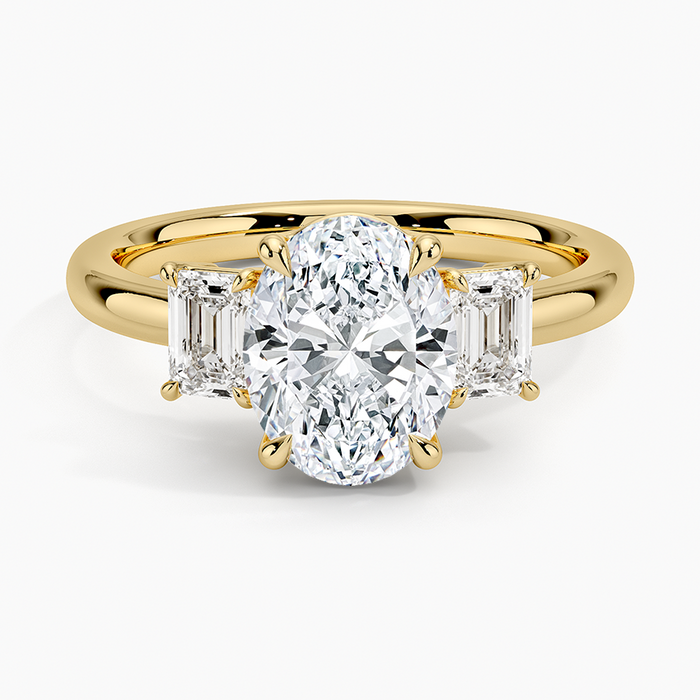 Oval moissanite with large emerald cut side stones in yellow gold, top view