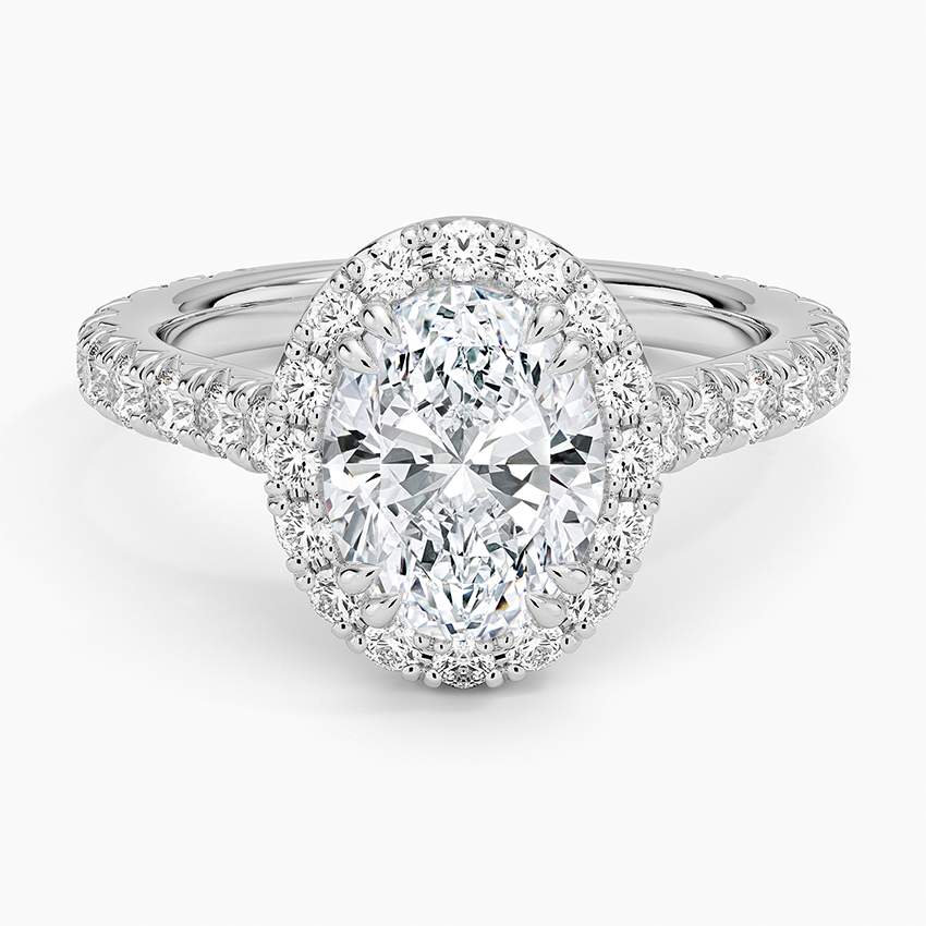 Oval moissanite in a full halo with three quarter pave band in white gold