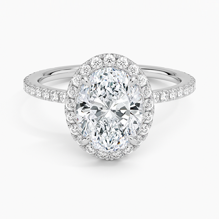 Oval moissanite with a full pave halo and pave band in white gold, top view
