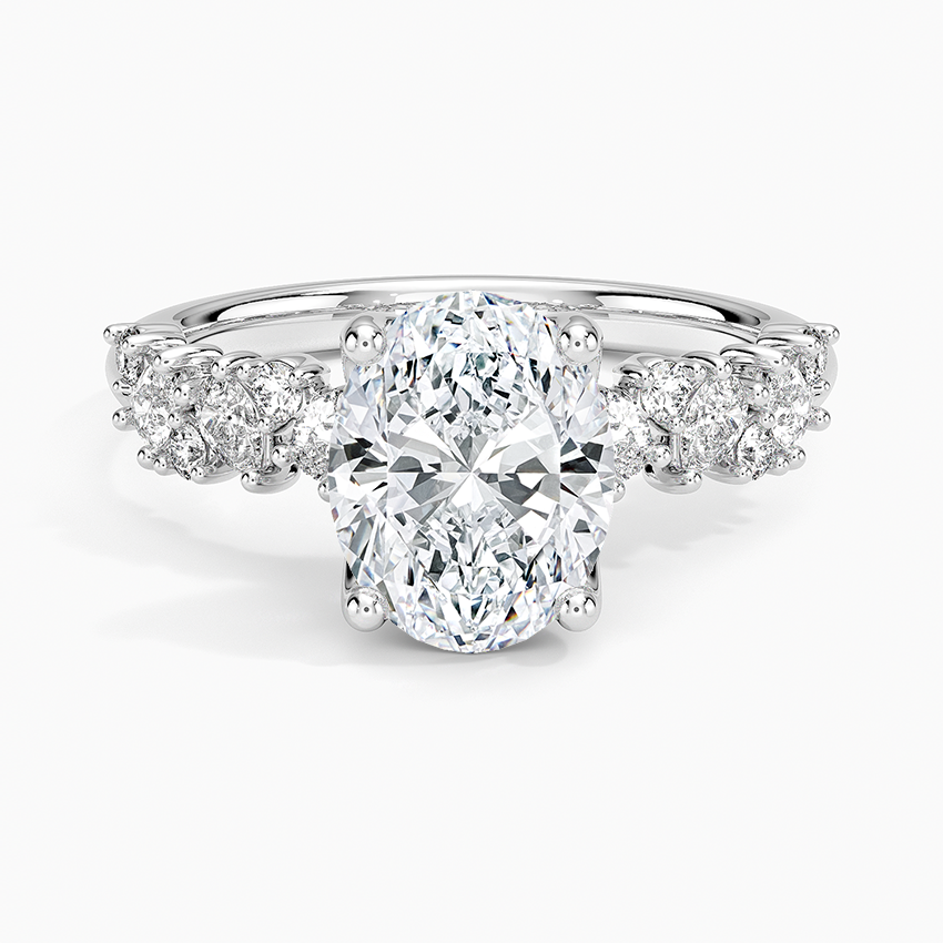 Oval moissanite with clustered round accents in white gold, top view