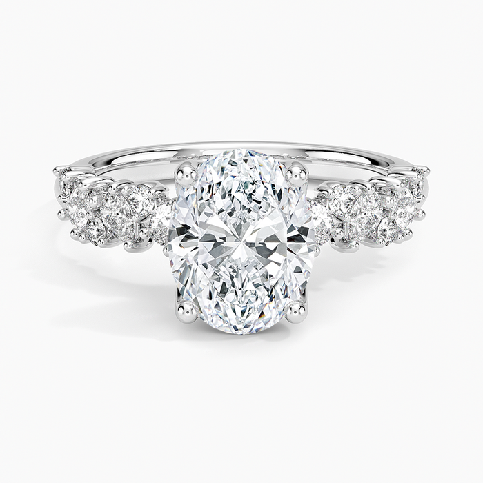 Oval moissanite with clustered round accents in white gold, top view
