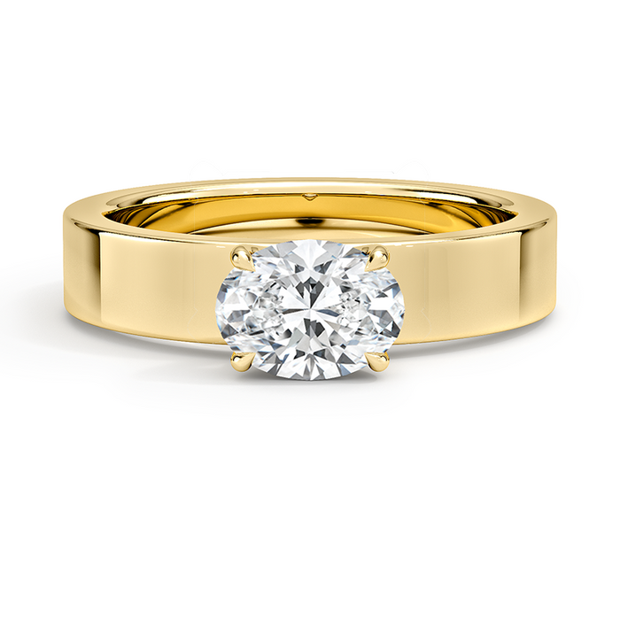 Oval moissanite set east west low into a wide flat yellow gold band, front view