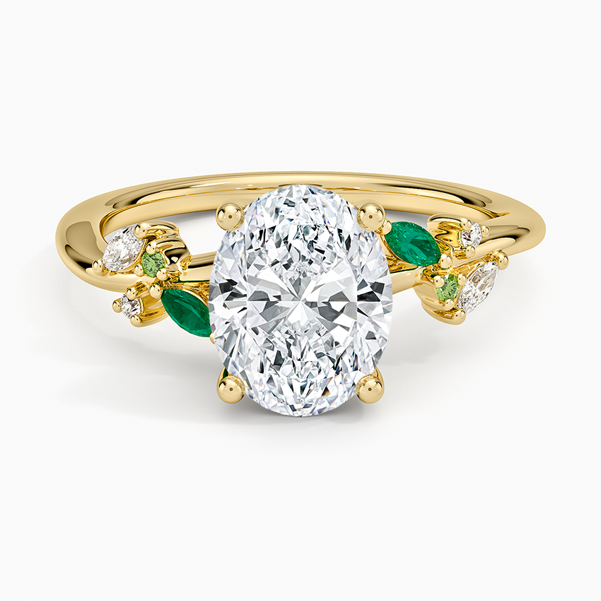 Oval moissanite engagement ring with green emerald leaf accents in yellow gold, top view
