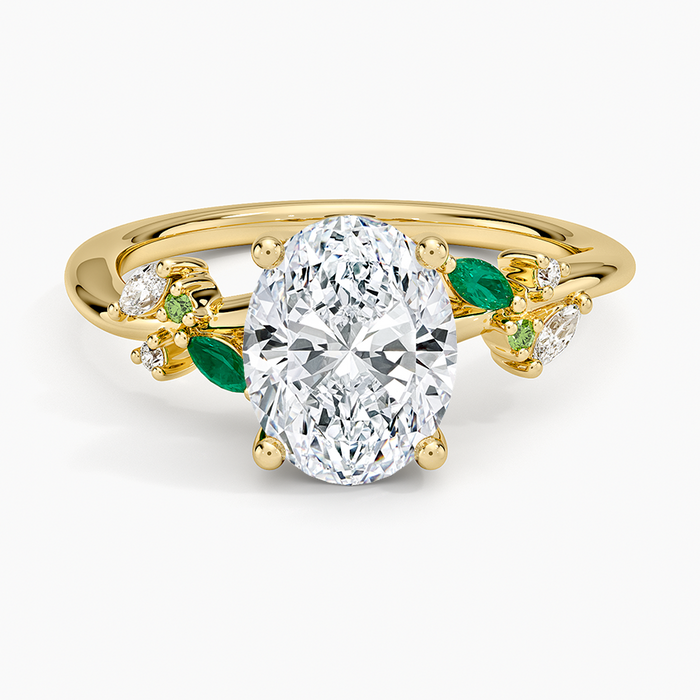 Oval moissanite engagement ring with green emerald leaf accents in yellow gold, top view