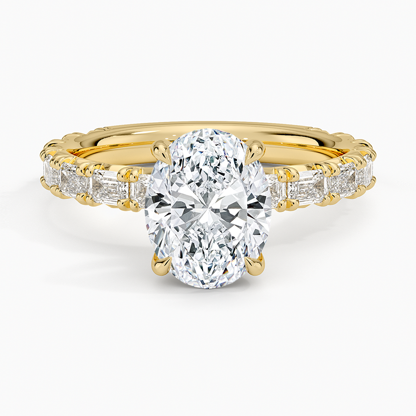 Oval moissanite with emerald cut accent shoulders in yellow gold, top view