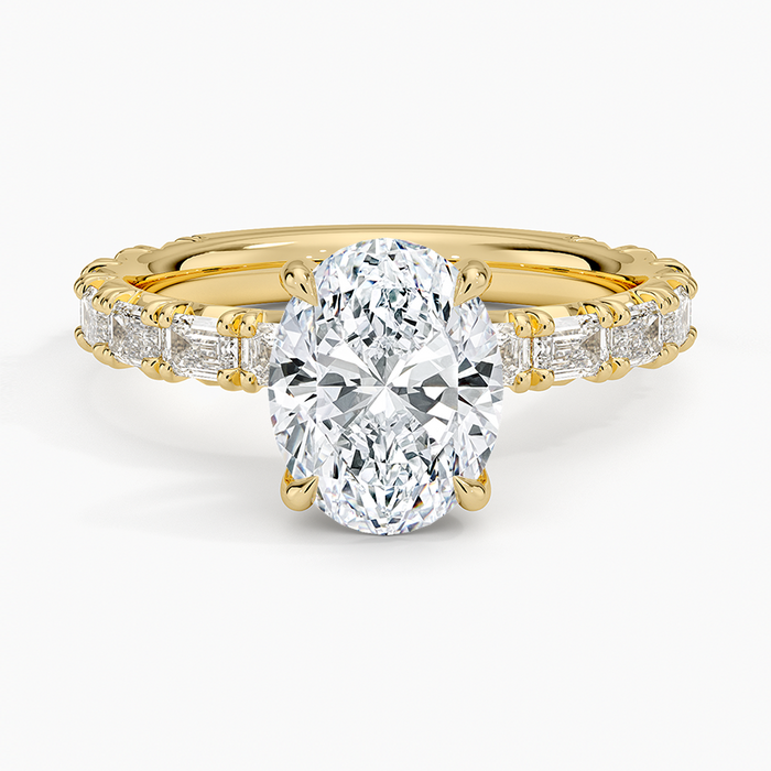 Oval moissanite with emerald cut accent shoulders in yellow gold, top view