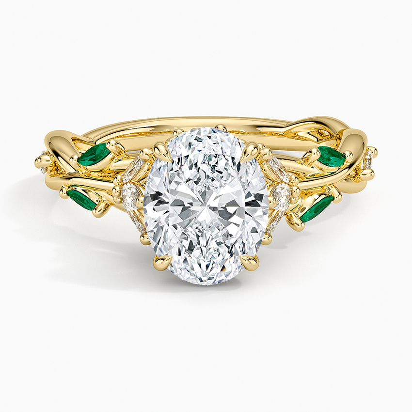 Oval moissanite on a twisted vine with green emerald marquise leaves in yellow gold