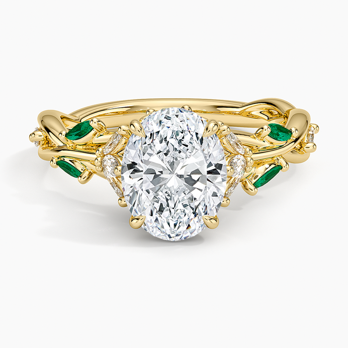 Oval moissanite on a twisted vine with green emerald marquise leaves in yellow gold
