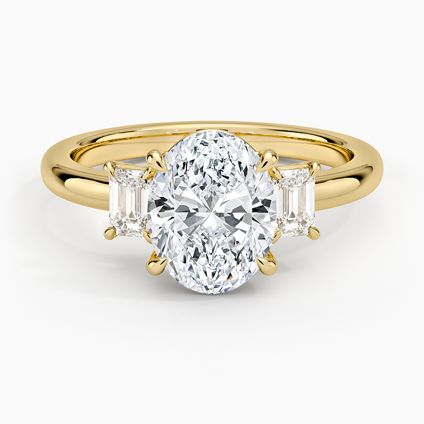 Oval moissanite with emerald cut side stones in yellow gold, top view