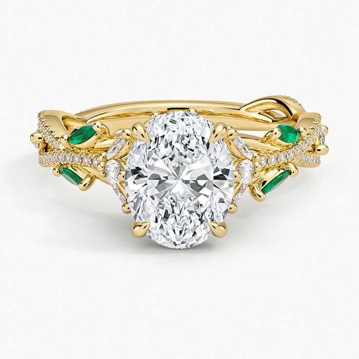 Oval moissanite ring with green emerald leaves and pave vine in yellow gold, top view