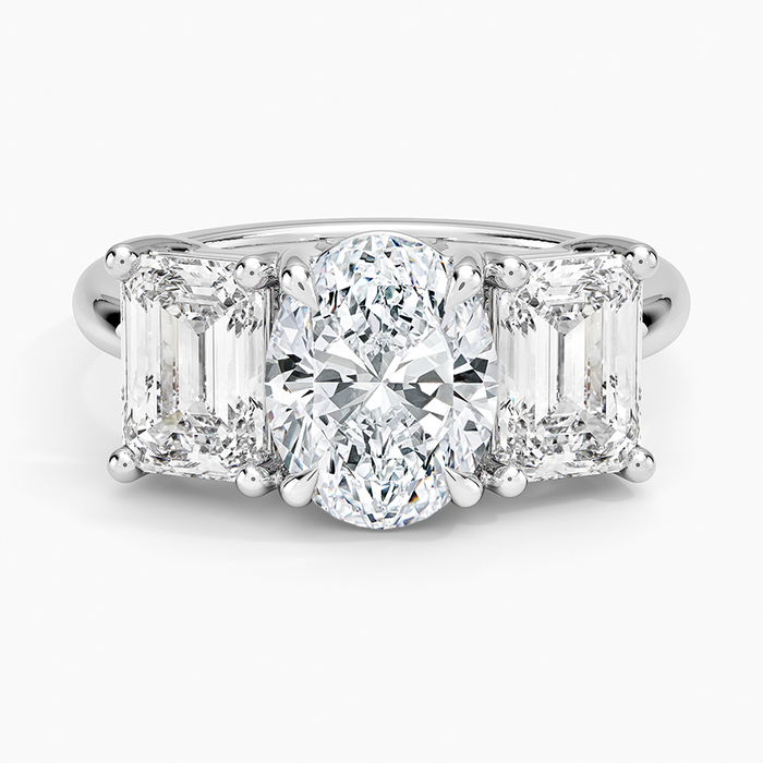Oval moissanite three stone ring with east west emerald cut side stones in white gold, top view