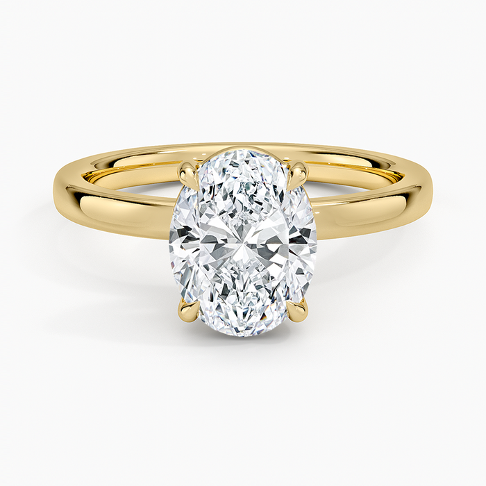 Oval moissanite low set on a flat top band in yellow gold, top view