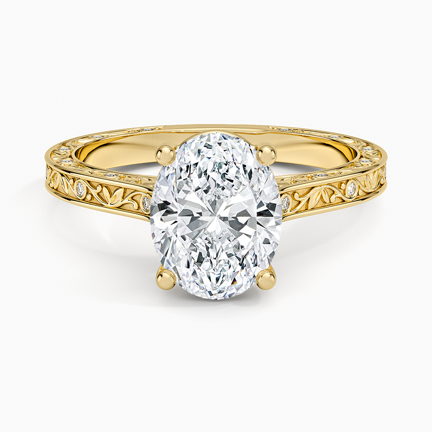 Oval moissanite on an engraved vine band with flush set accents in yellow gold