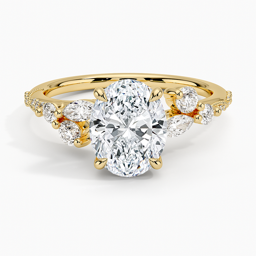 Oval moissanite ring with graduated accent clusters and milgrain pave band in yellow gold, top view