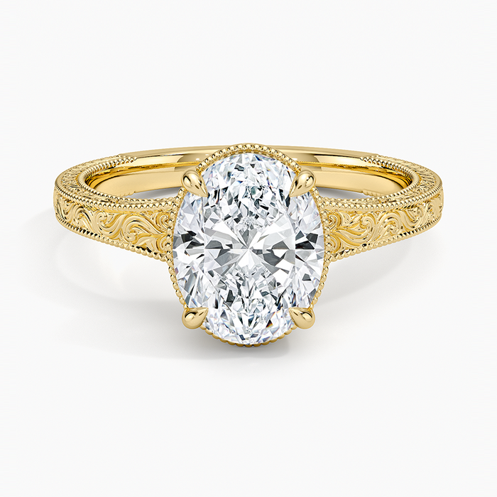 Oval moissanite on a hand engraved scroll and milgrain band in yellow gold, top view