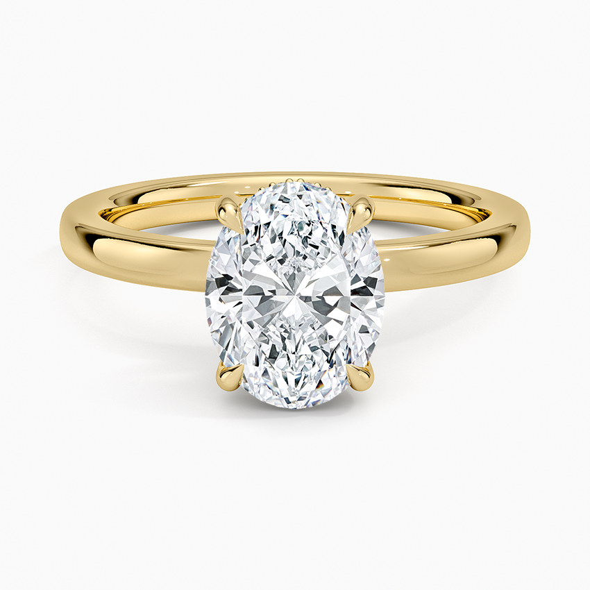 Oval moissanite hidden halo engagement ring in yellow gold with tapered shoulders, top view