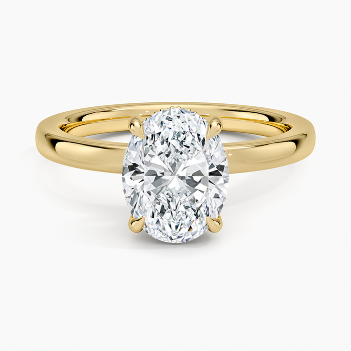 Oval moissanite hidden halo engagement ring in yellow gold with tapered shoulders, top view