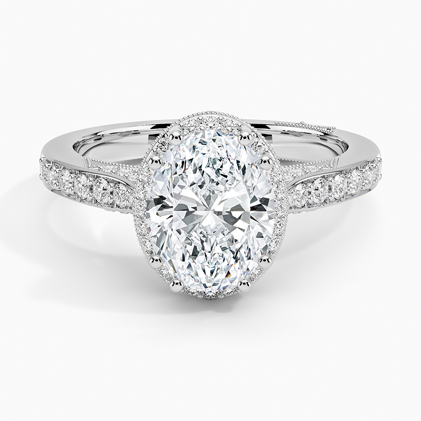Oval moissanite in a milgrain edged halo with tapered pave in white gold, top view