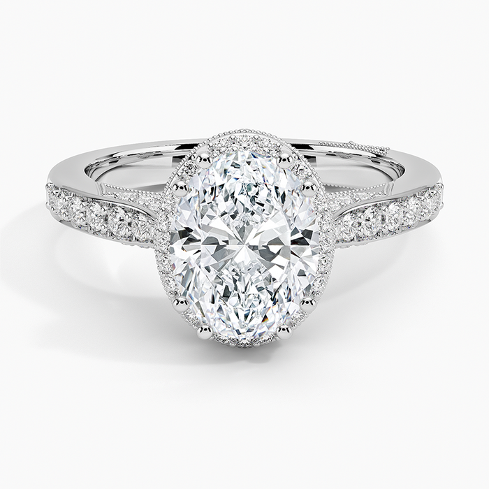 Oval moissanite in a milgrain edged halo with tapered pave in white gold, top view