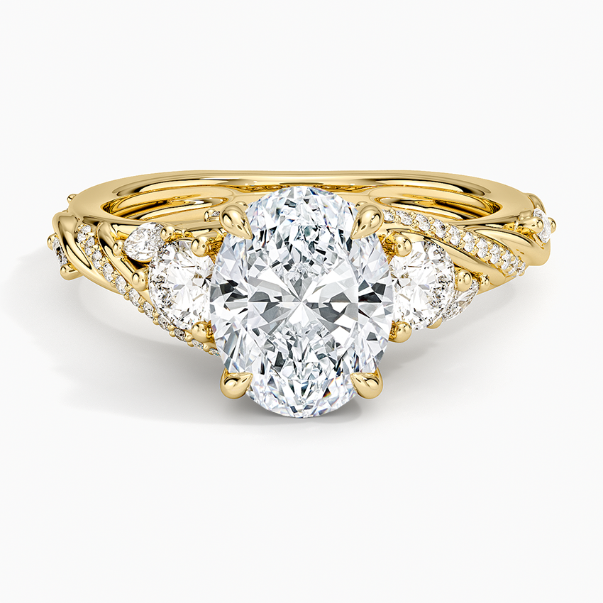 Oval moissanite three stone ring with marquise leaves and pave vine shoulders in yellow gold