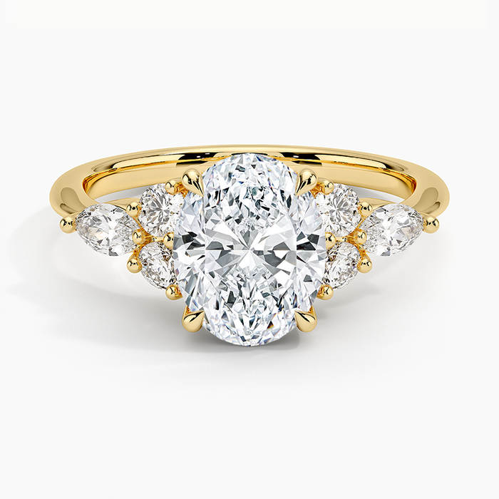 Oval moissanite engagement ring with pear and round cluster accents in yellow gold