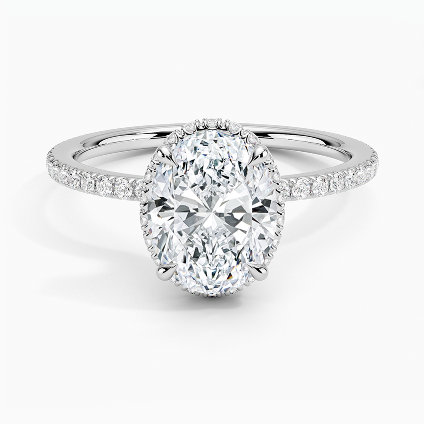 Oval moissanite with a peekaboo halo showing past the stone edge, white gold, top view
