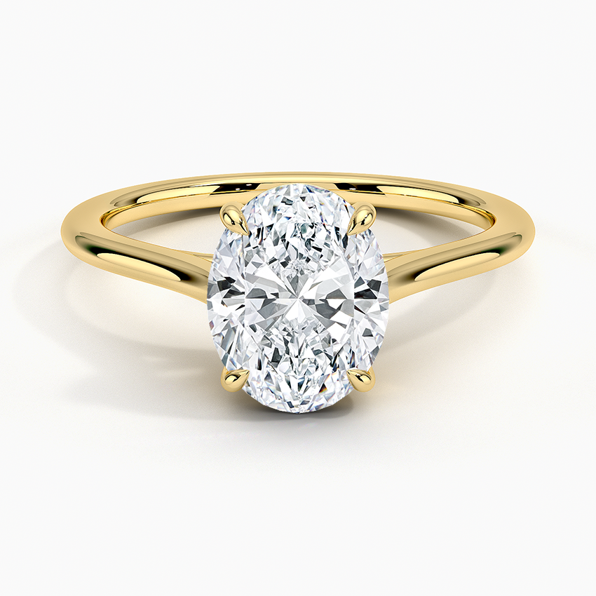 Oval moissanite low set on a petite tapered band in yellow gold, top view