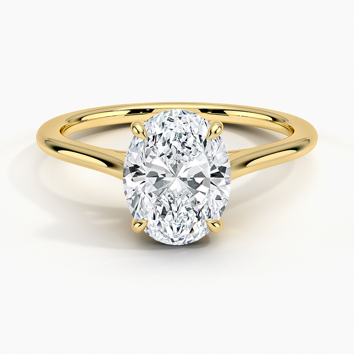 Oval moissanite low set on a petite tapered band in yellow gold, top view