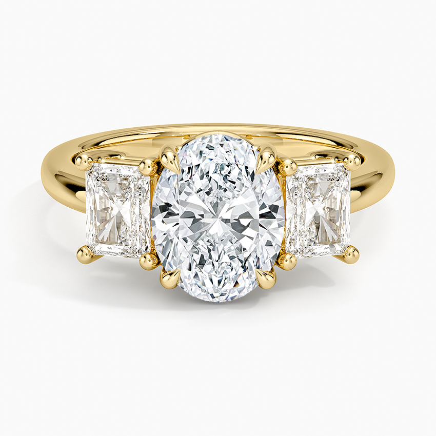 Oval moissanite with two radiant cut side stones in yellow gold, top view