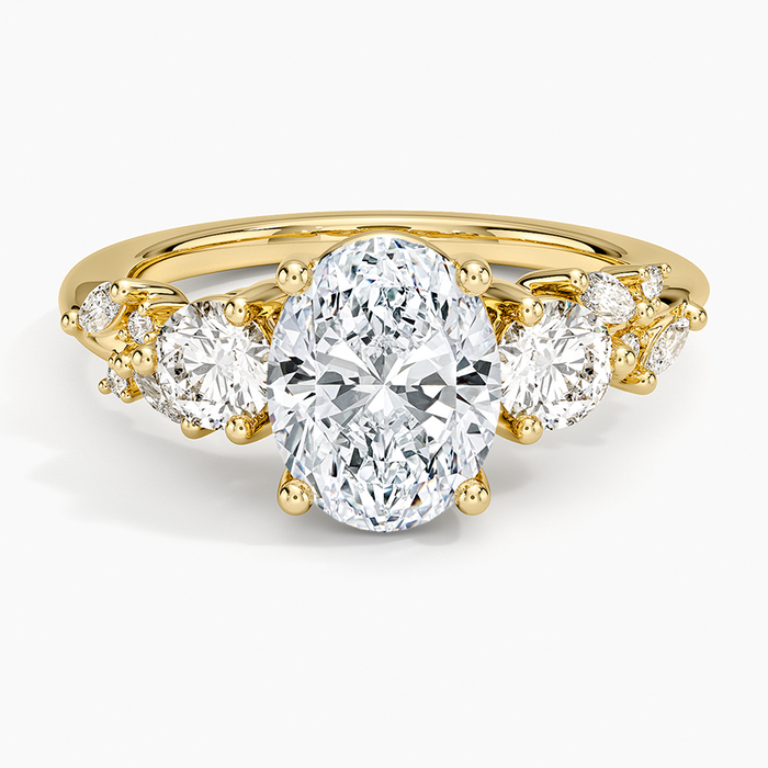 Oval moissanite with round side stones and scattered marquise accents in yellow gold, top view