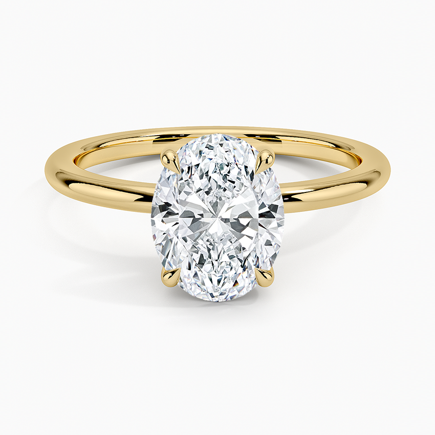 Oval moissanite on a round wire band in yellow gold, top view