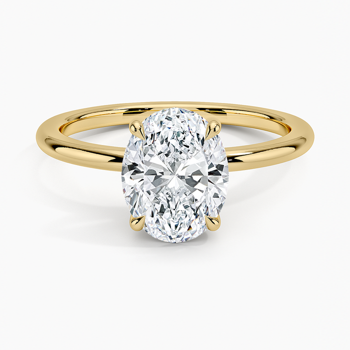Oval moissanite on a round wire band in yellow gold, top view