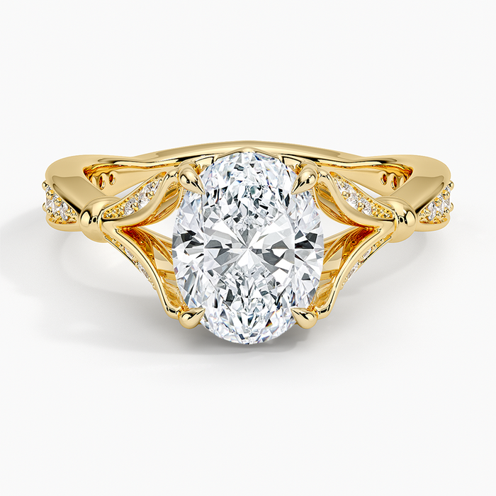 Oval moissanite framed by open pave scroll wings in yellow gold, top view