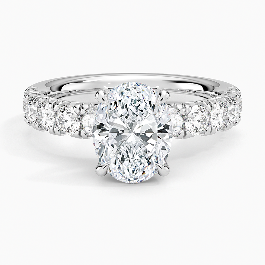 Oval moissanite on a large shared prong accent band in white gold, top view