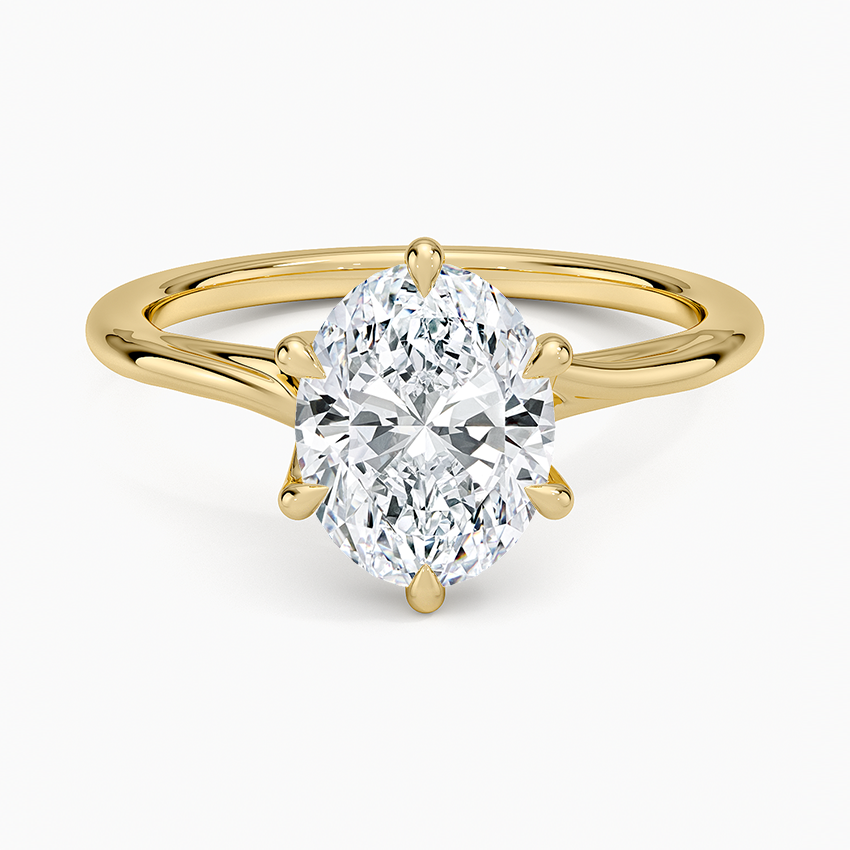Oval moissanite solitaire in six petal tipped prongs on a slim yellow gold band, top view