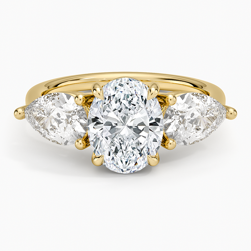 Oval moissanite statement three stone ring with large pear sides in yellow gold, top view