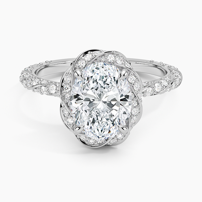 Oval moissanite inside a swirling pave knot halo in white gold, top view