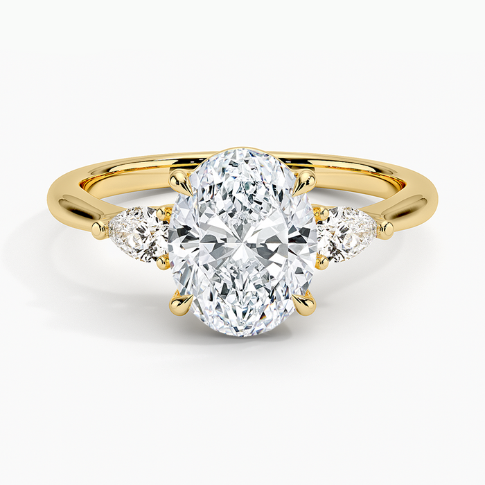 Oval moissanite three stone ring with pear side stones in yellow gold, top view