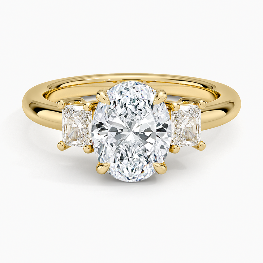 Oval moissanite three stone ring with upright radiant cut side stones in yellow gold, top view