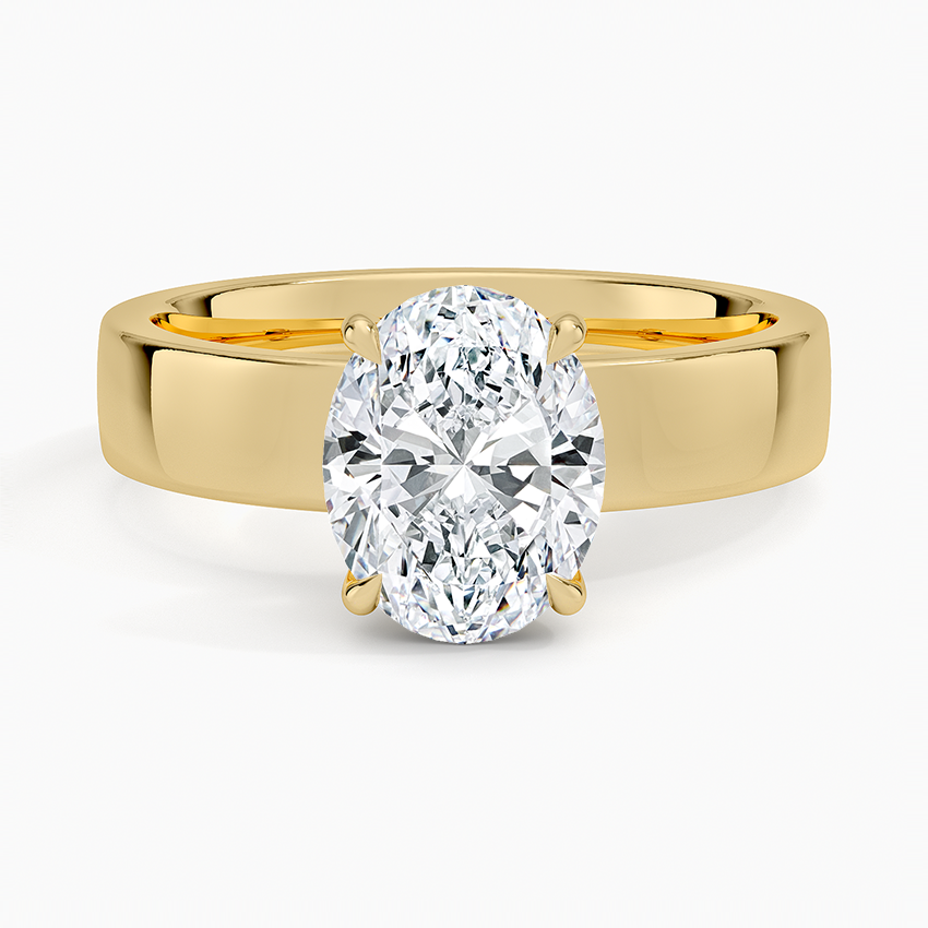 Oval moissanite solitaire on a wide flat yellow gold band, top view