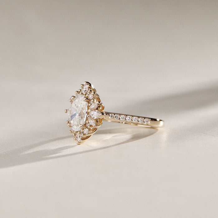 Oval cut moissanite vintage mixed cut halo engagement ring on a pave band in yellow gold, view 2