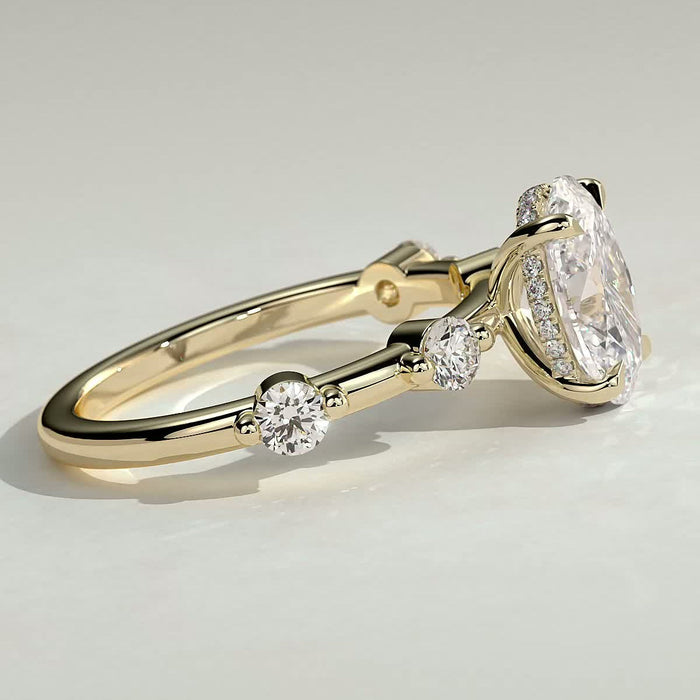 Oval cut moissanite engagement ring with widely spaced round accents in yellow gold, view 2