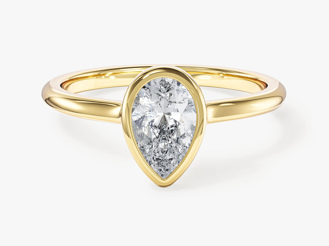 Dainty pear moissanite bezel engagement ring in yellow gold, front view