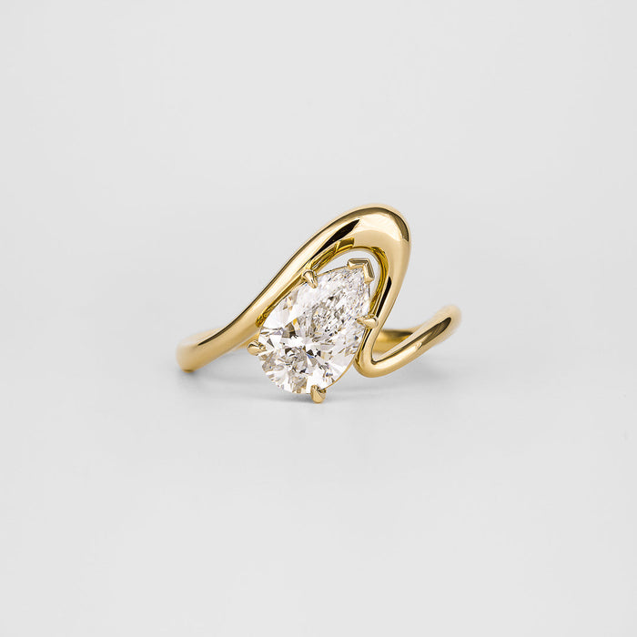 Pear cut moissanite angled curved shank solitaire engagement ring in yellow gold