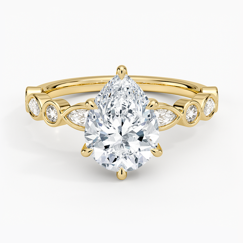 Pear cut moissanite bezel set marquise and round engagement ring in yellow gold, top view