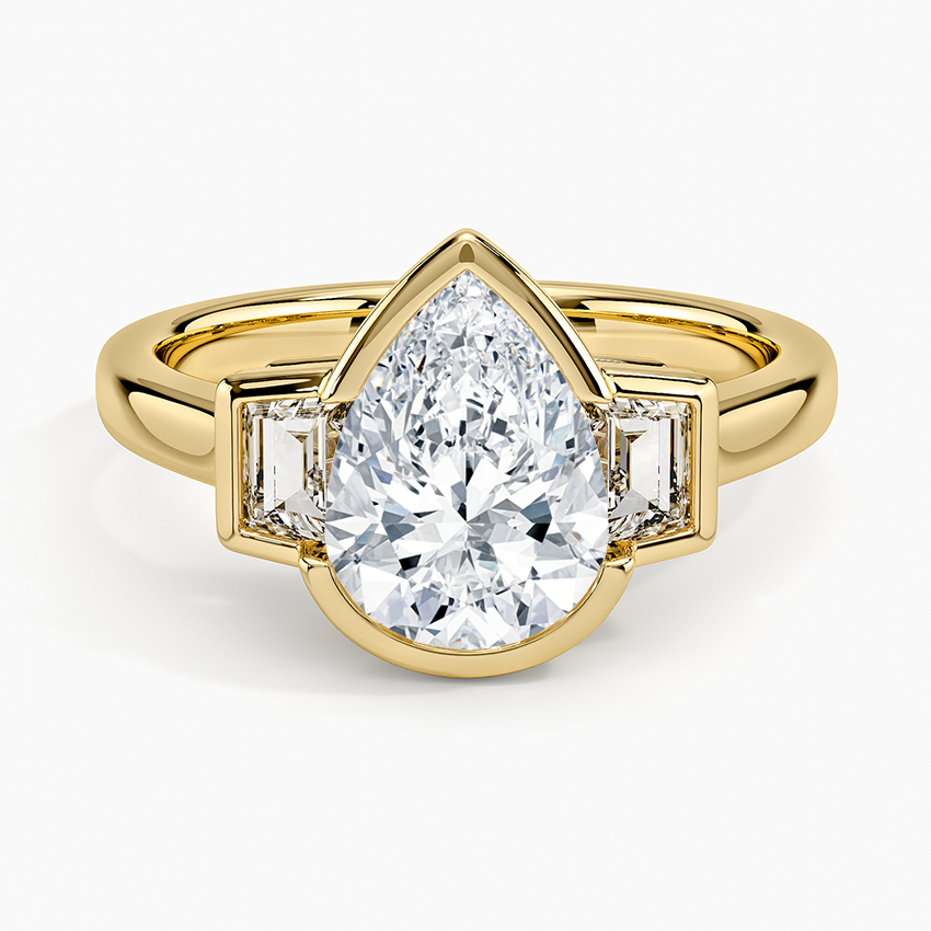 Bezel set pear cut moissanite flanked by tapered baguettes in yellow gold, top view
