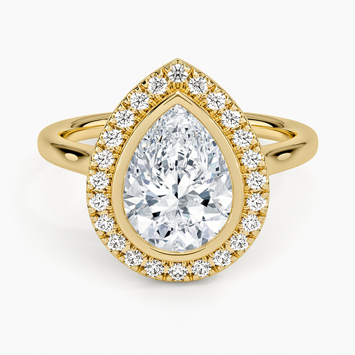 Pear cut moissanite bezel set pave halo engagement ring in yellow gold, top view